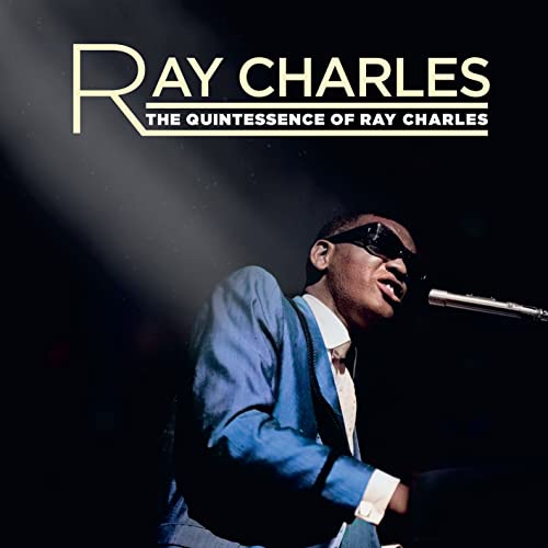 Ray Charles wearing sunglasses and a blue suit, performing at a piano on stage.