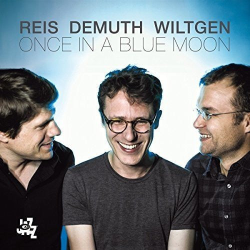 CD cover featuring three men with glasses, smiling, against a blue background.
