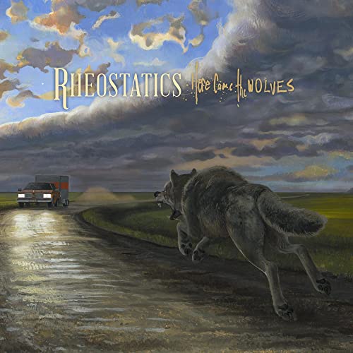 Album cover: wolf running towards a truck on a dirt road.