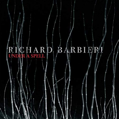 Album cover for Richard Barbieri’s “Under A Spell” with dark, bare trees.