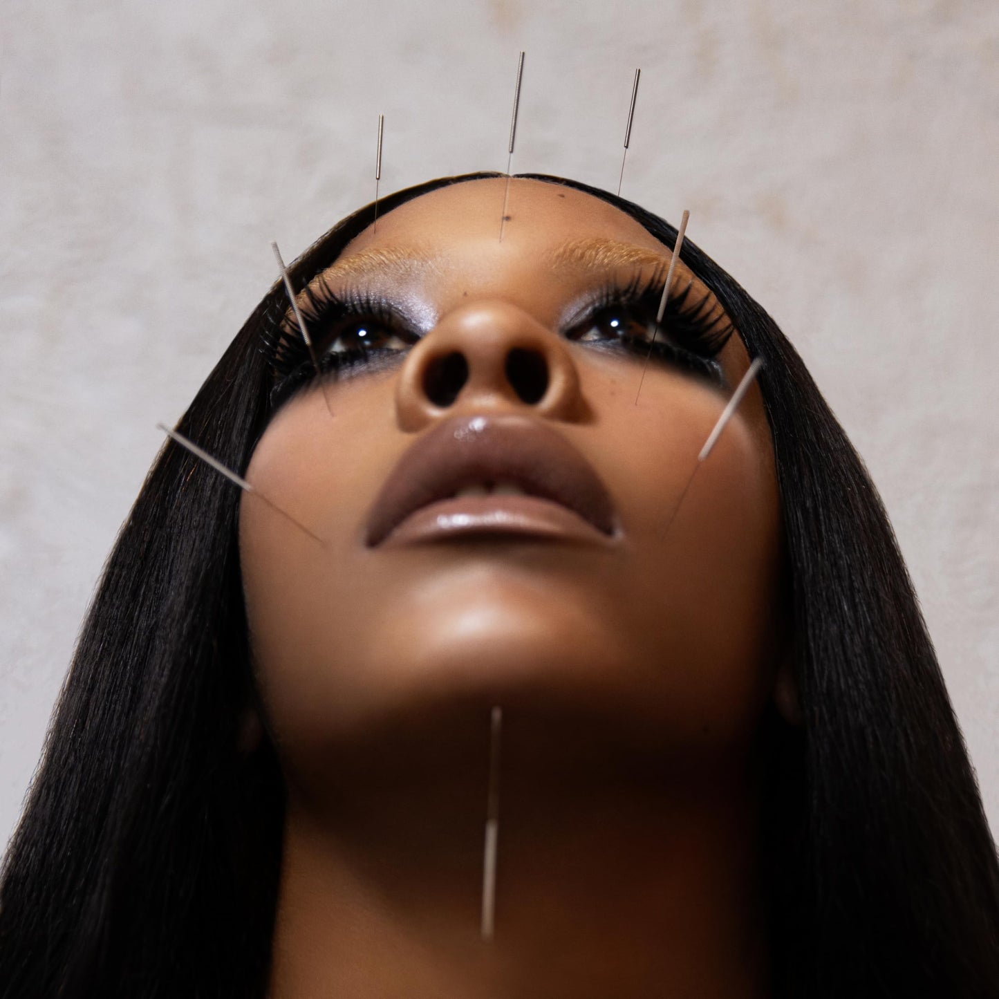 Close-up of Rico Nasty with acupuncture needles on her face and neck.