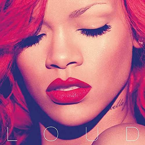 Close-up portrait of Rihanna with bright red hair and red lipstick.