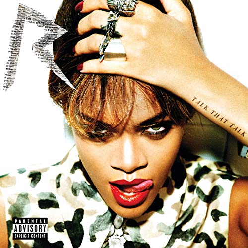 Rihanna with red lipstick and tongue out, wearing a camouflage top and rings.