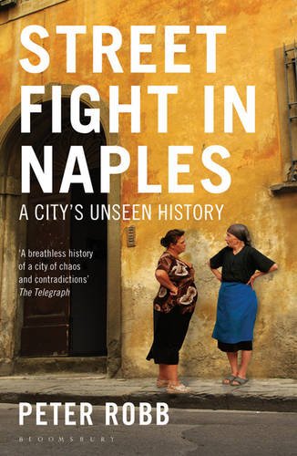 Book cover: two women stand before a weathered, yellow building.