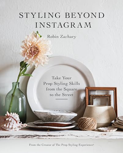 Book cover with flower, plates, and decorative objects on a shelf.