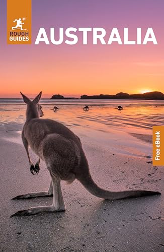 A kangaroo stands on a beach at sunset on the cover of Australia guidebook.