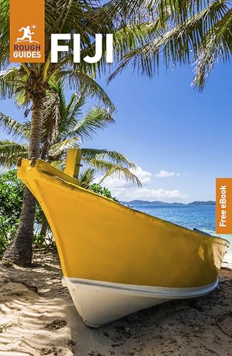 A yellow boat rests on a sandy beach under palm trees by the ocean.