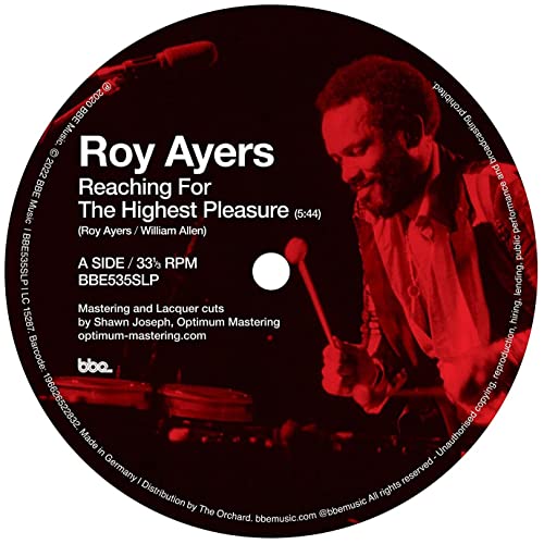 Roy Ayers vinyl record label with a red-toned image of him playing vibraphone.