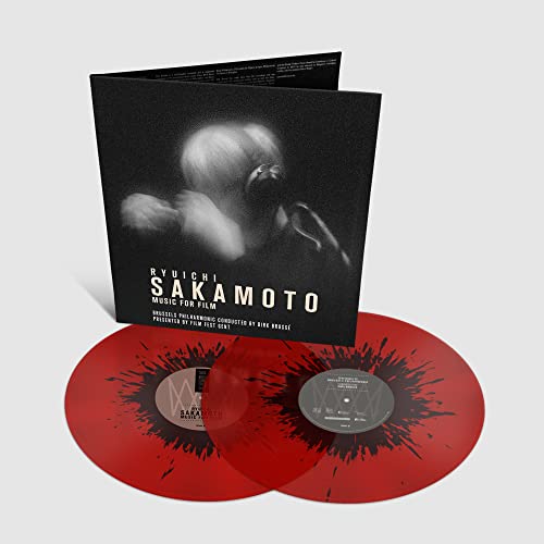 Red splatter vinyl records and black album cover with a portrait.
