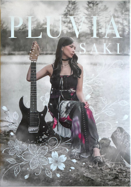 CD cover: woman with guitar, floral design, misty background.