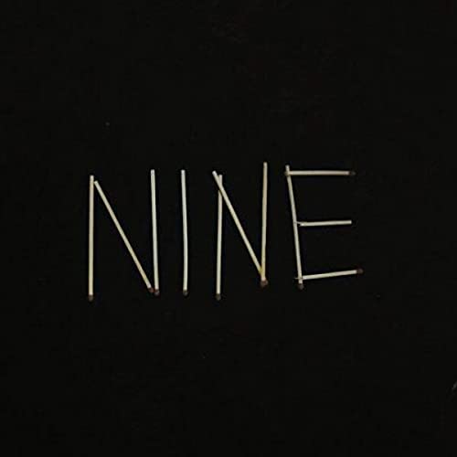 The word NINE spelled out with matchsticks against a plain black background.