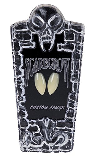 White plastic vampire fangs on black card with skull design.