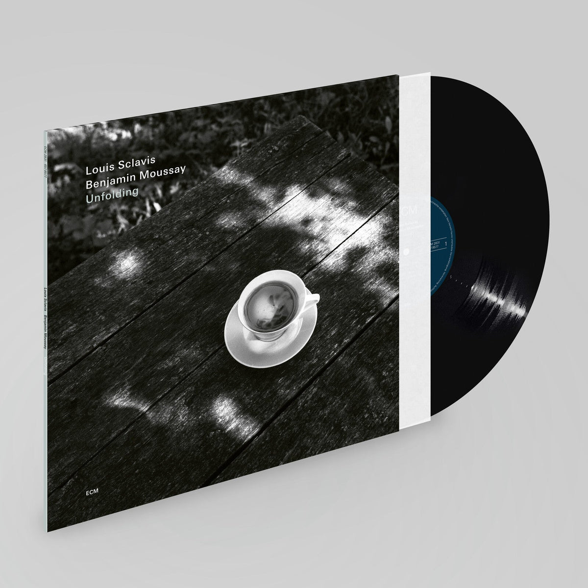 Vinyl record cover featuring a coffee cup on a textured surface.