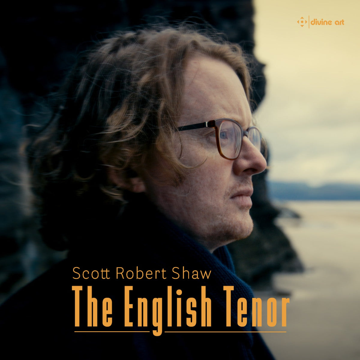 Portrait of Scott Robert Shaw, a tenor, with glasses and curly hair.