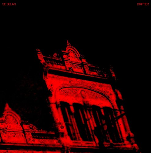 Red monochrome album cover featuring a blurred, ornate building facade.