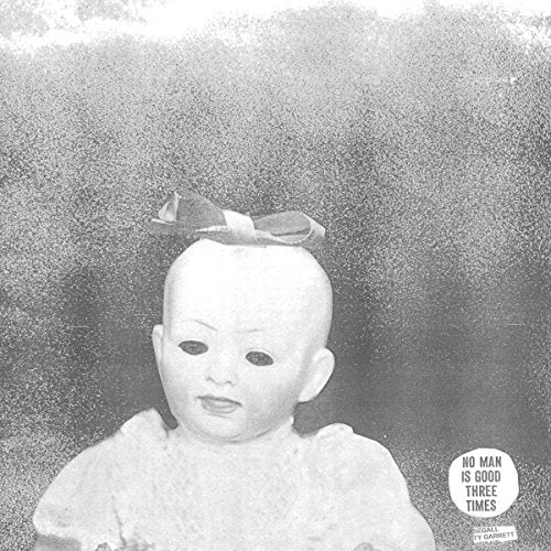 Black and white portrait of a baby doll with a ribbon, text overlay.