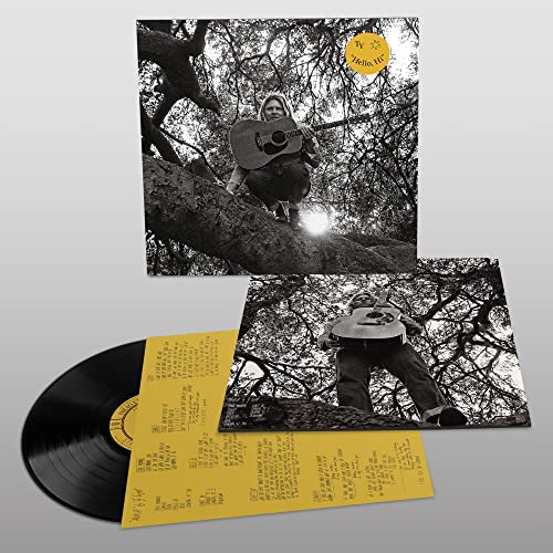 Black vinyl record with black and white album cover of a musician in a tree.