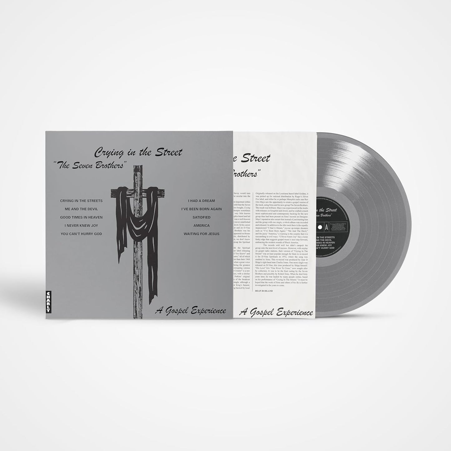 Vinyl record with album cover depicting a cross and text, grayscale.