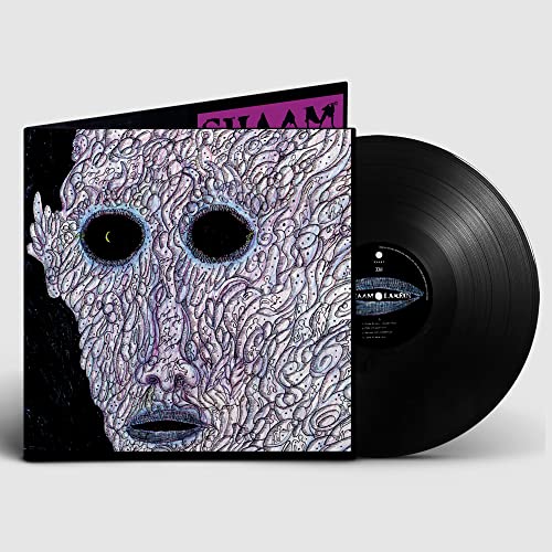 Vinyl record with album cover featuring a distorted, patterned face and yellow eyes.