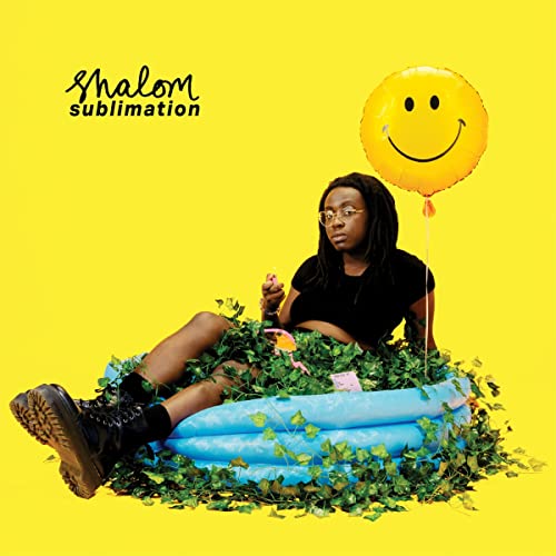 Person in a pool with plants, holding a small object, yellow background.