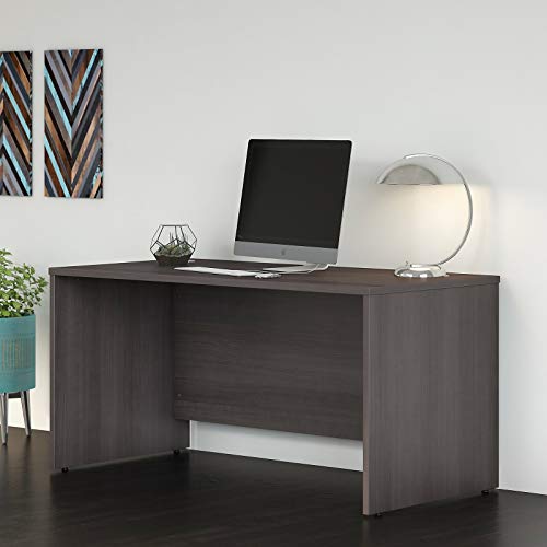 CD case displayed on a dark wood desk with computer and decor.