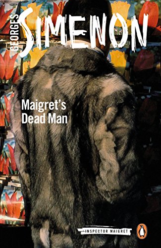 A person in a fur coat stands before a display of red and yellow tulips.