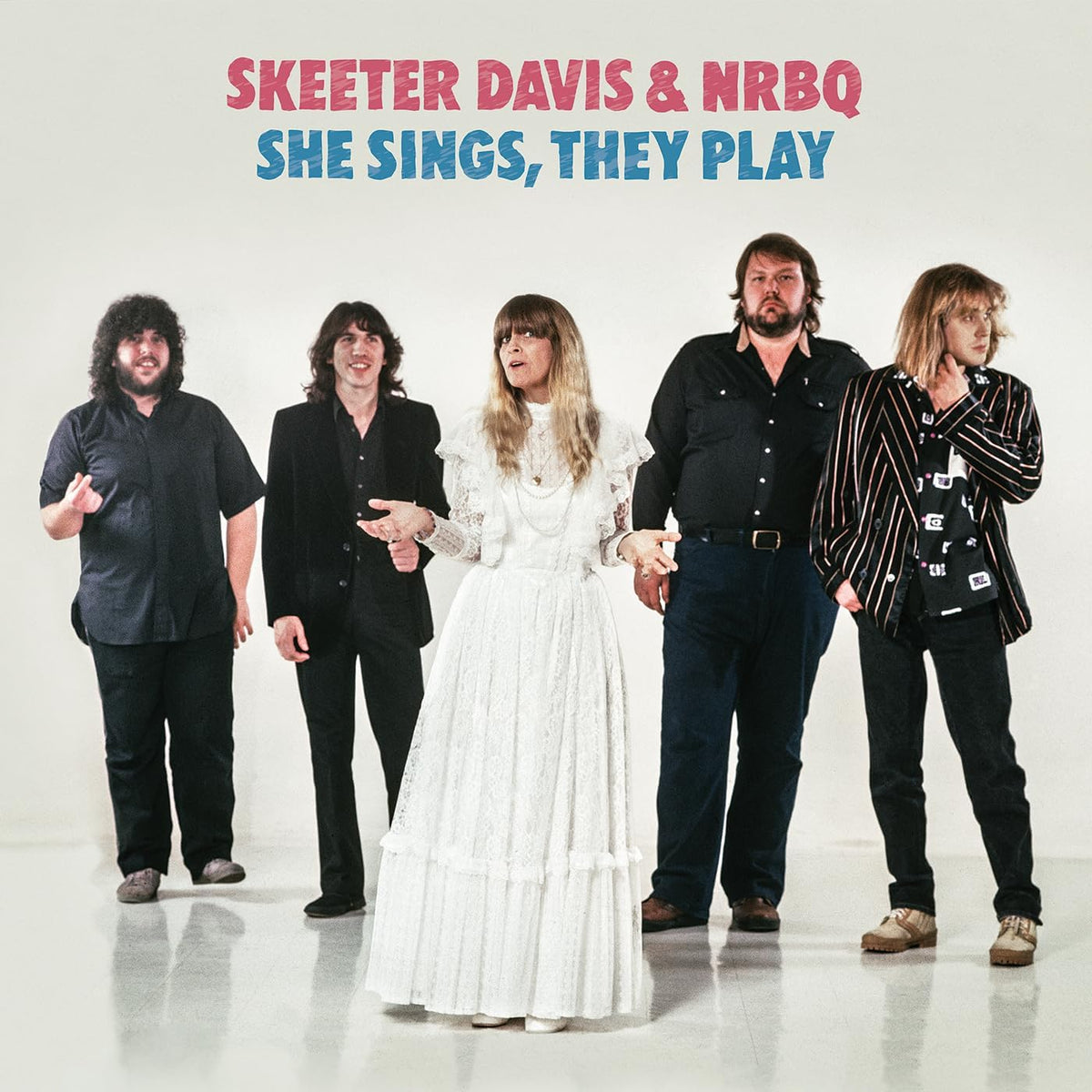 Skeeter Davis and NRBQ pose in vintage clothing on a pale background.