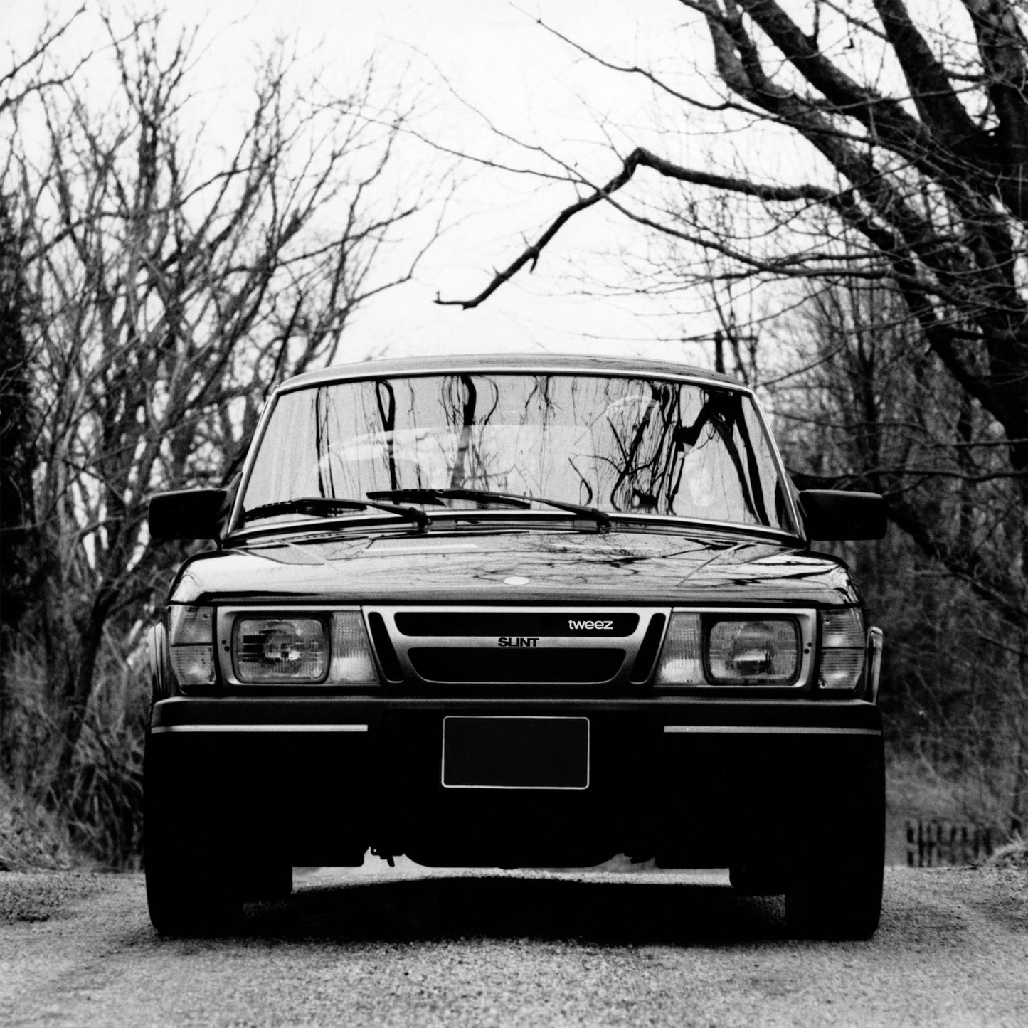 Black and white photo of a car’s front grill with “Slint” text.