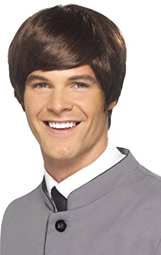 A man wearing a brown mod wig, grey jacket, and black tie, smiling.