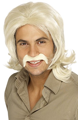 Man wearing a blonde wig and false mustache, smiling, against a white background.