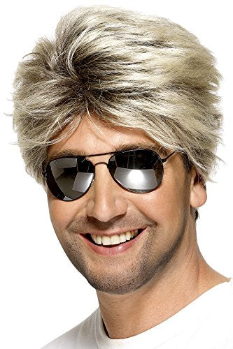 Man wearing a blonde, feathered wig and reflective sunglasses, smiling against a white background.