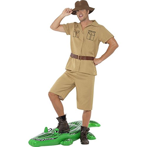 Man in khaki safari outfit standing on green inflatable crocodile toy.