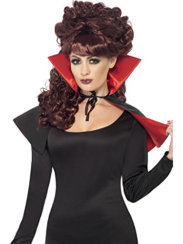 A woman dressed as a vampire, wearing a red and black cape and curly wig.