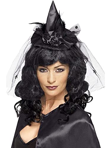 A woman wearing a black mini witch hat with a veil and spider accents.