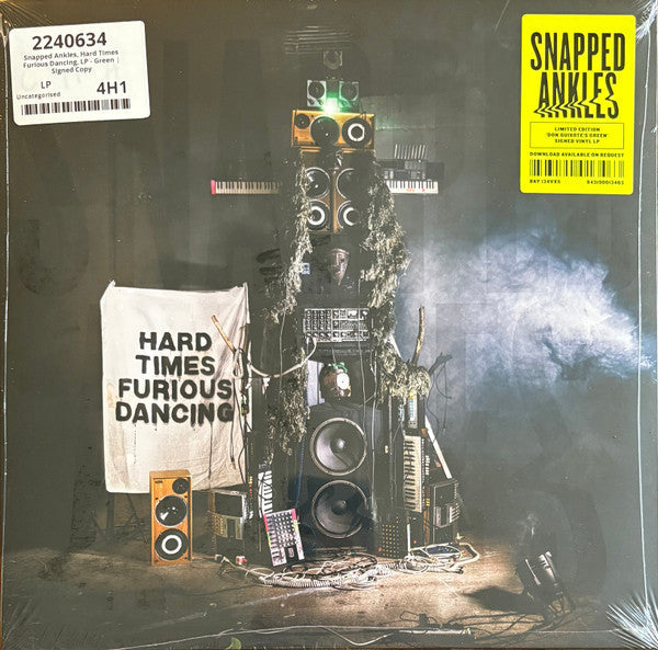 Vinyl record cover with a chaotic stack of audio equipment and banner.