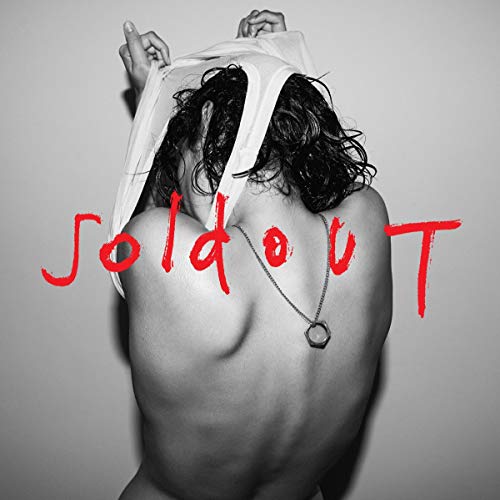 Person seen from behind pulling a white shirt over their head with red text.