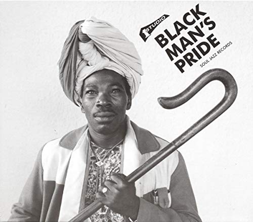 Black and white portrait of a man with a turban and walking stick.