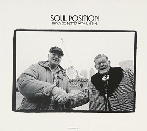 Black and white album cover featuring two men shaking hands outdoors.