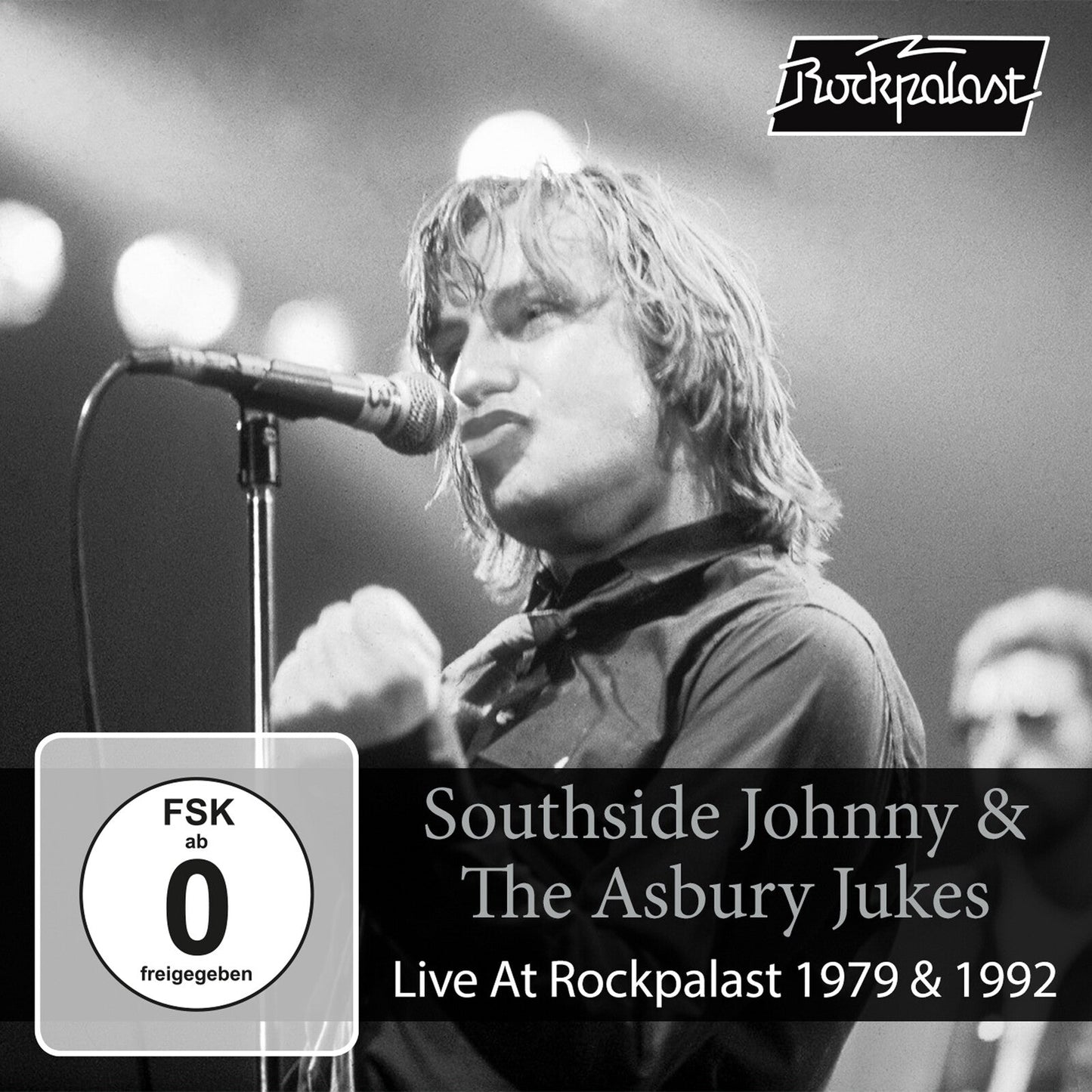 Black and white concert photo of Southside Johnny singing into a microphone.