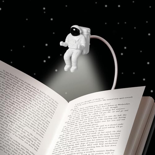 White spaceman figure book light floats above an open book.