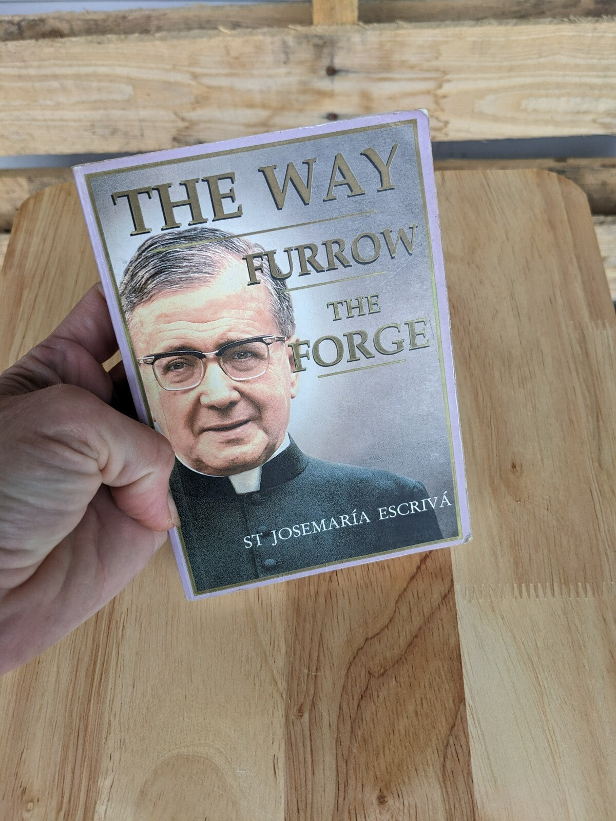 Paperback book, āThe Way, Furrow, The Forgeā with a portrait of St. Escriva.