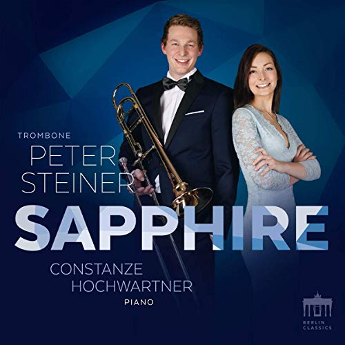 A man holding a trombone and a woman in formal attire on a blue background.
