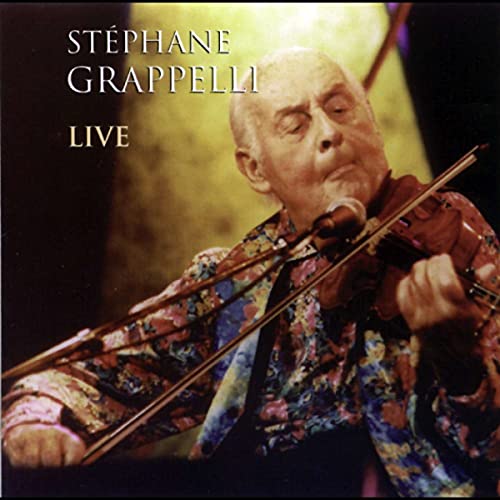 Stephane Grappelli playing violin on stage, wearing a colorful patterned shirt.
