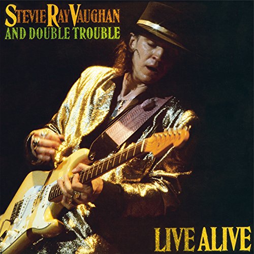 Stevie Ray Vaughan playing a yellow electric guitar on album cover.