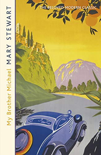 A vintage blue car drives on a road toward mountains beneath orange trees.