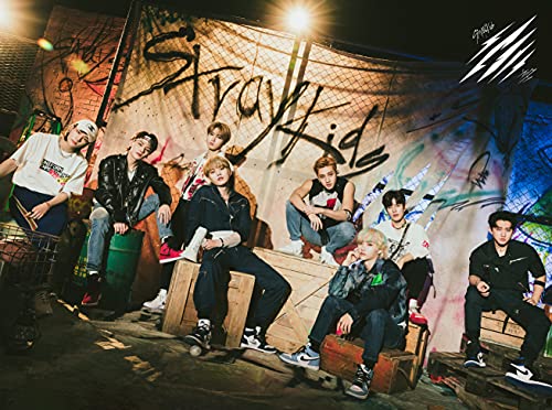Stray Kids, eight members posing amongst graffiti and urban debris.