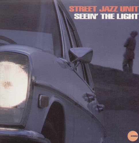 Vinyl record cover: car headlight, distant figure, and album title.