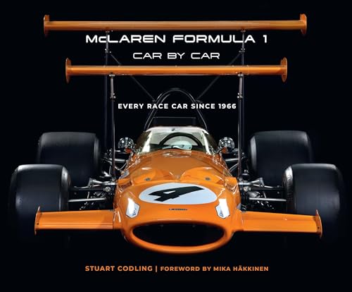 Front view of an orange vintage McLaren Formula 1 race car on black background.
