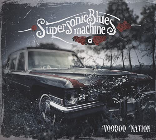 A vintage car sits in a field under the Supersonic Blues Machine band logo.
