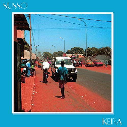 The image depicts a vibrant street scene with a red sidewalk and various vehicles. For accessibility purposes, a concise alt text could be: "Album cover with a photo of a busy street with red sidewalk."